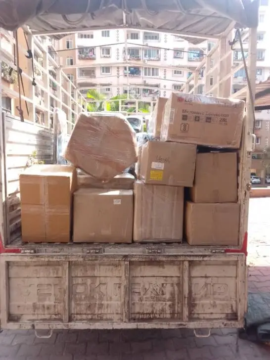 House Shifting in Ambattur Chennai - Real photo of multi-layer corrugated packing, stretch wrapping, and LR consignment tagging on moving vehicle
