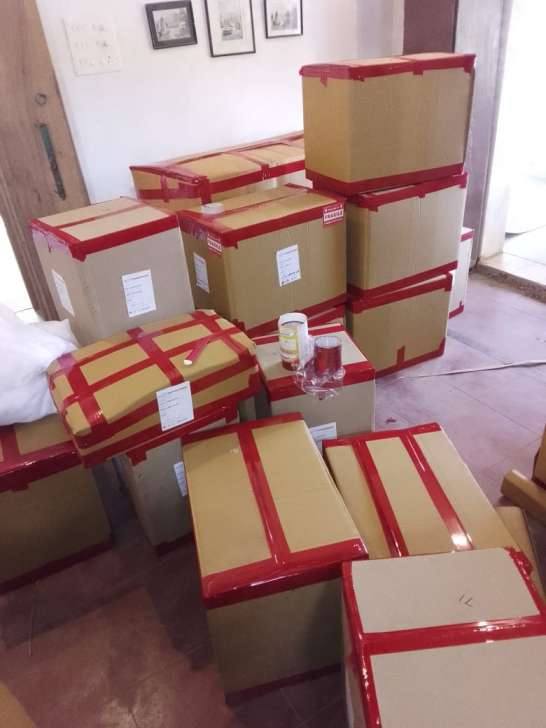 Systematic room-wise corrugated box packing, red industrial edge sealing, and white inventory labeling staged inside Chennai residence for Visakhapatnam shifting